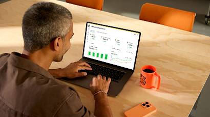 Person working at wooden desk with laptop and orange coffee mug, shown from multiple angles in progressive shots
