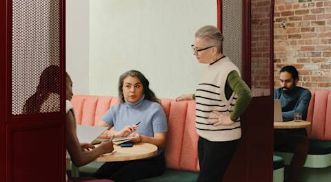 3 people discussing business in a cafe booth