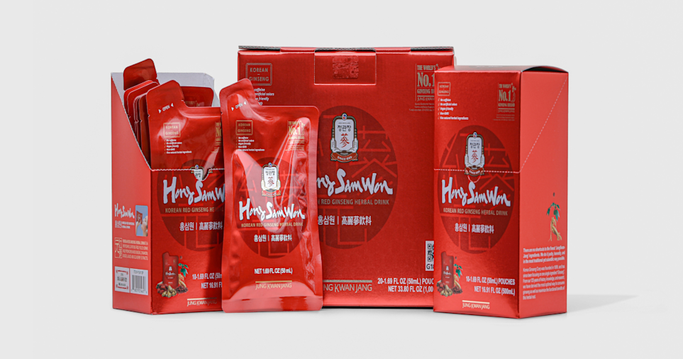 Studio product image of red HongSamWon Korean red ginseng herbal drink packaging, including individual drink pouches and multiple box sizes, arranged side by side on a light gray background with labels facing forward. 