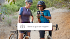 Duas mulheres em um passeio de bicicleta, parando para baixar um aplicativo de guia de viagem oferecido por uma campanha do Mailchimp.