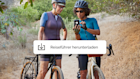 Zwei Frauen bei einer Radtour, die anhalten, um einen Reiseführer herunterzuladen, der von einer Mailchimp-Kampagne angeboten wird.