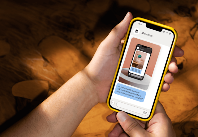 Uma pessoa segurando o celular que mostra a tela do SMS