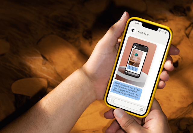 Eine Person, die ein Handy hält, auf dem ein SMS-Bildschirm angezeigt wird