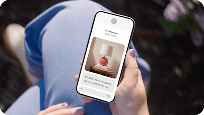 Image depicting a person holding a smartphone displaying a text message from the fictitious brand Assembly. The visual demonstrates how businesses can boost sales with abandoned cart automations and recover lost sales opportunities.