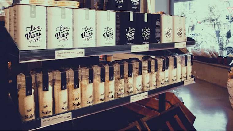 Retail display shelves stocked with white-labeled "Love Viani 1973" products, arranged in neat rows with price tags visible below