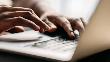 Close-up shot of hands typing on a laptop computer