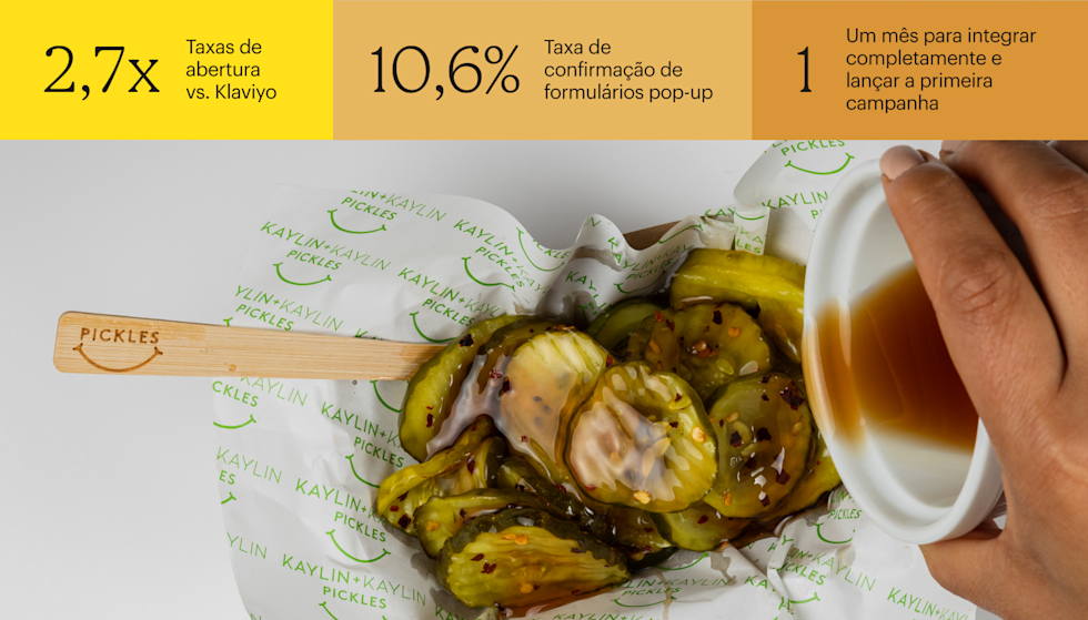 Tiras de picles regadas com molho branco em papel da marca com um padrão com o logotipo de rosto sorridente verde e garfo de madeira