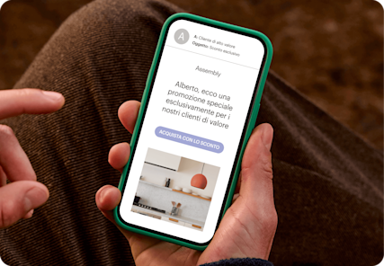 Immagine di una persona che guarda lo schermo di uno smartphone che mostra un'e-mail del brand fittizio Assembly. L'immagine mostra come personalizzare le campagne di marketing con segmenti basati sui dati dei clienti.