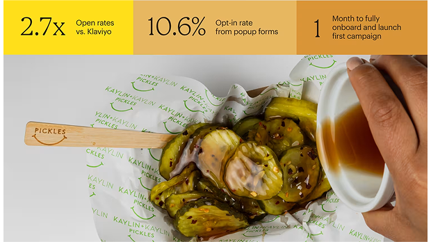 Wooden pickle spoon resting on branded paper next to a jar of pickles with brine, showing restaurant branding and presentation