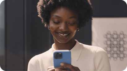 Image of a person looking at a smartphone. The visual suggests how users can increase engagement through SMS transactional follow-ups and customer support messages.