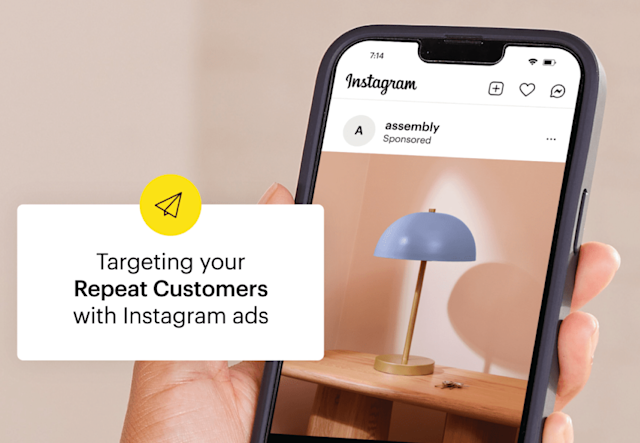 Instagram app interface showing sponsored post about targeting repeat customers, with blue desk lamp in background