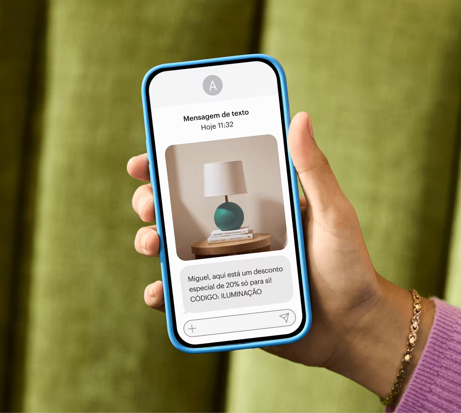 Mão exibindo um smartphone que acabou de receber uma mensagem de texto de marketing: "Alex, aqui está um desconto especial de 20% só para você!" CÓDIGO: ILUMINAÇÃO"
