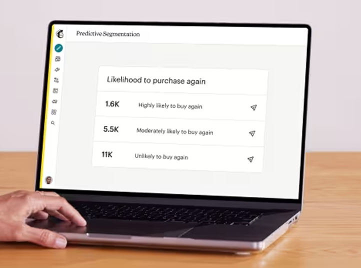 Laptop screen showing segmentation data with purchase likelihood categories and statistics on a wooden desk