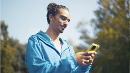 Person in blue jacket using smartphone while walking outdoors on sunny day, shown in multiple connected photos